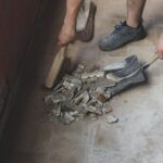Homeowner cleaning up debris and materials after successfully removing floor tile.