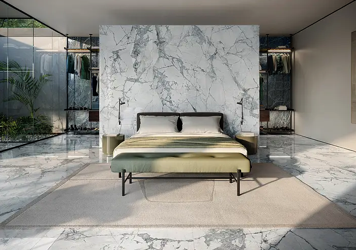 white marbled floors and a feature wall wtih white marble and grey veining in open concept bedroom