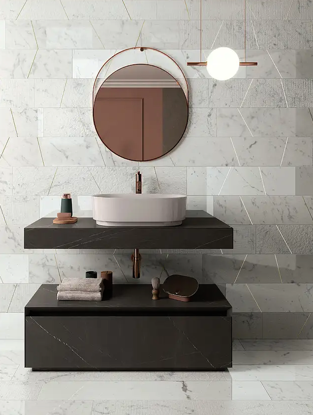 white marble subway tile with grey veining above a black bathroom sink and modern round white sink