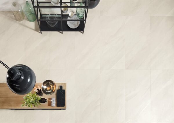 A top down view of pale white stone tiles flooring a kitchen