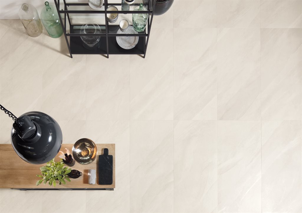 A top down view of pale white stone tiles flooring a kitchen