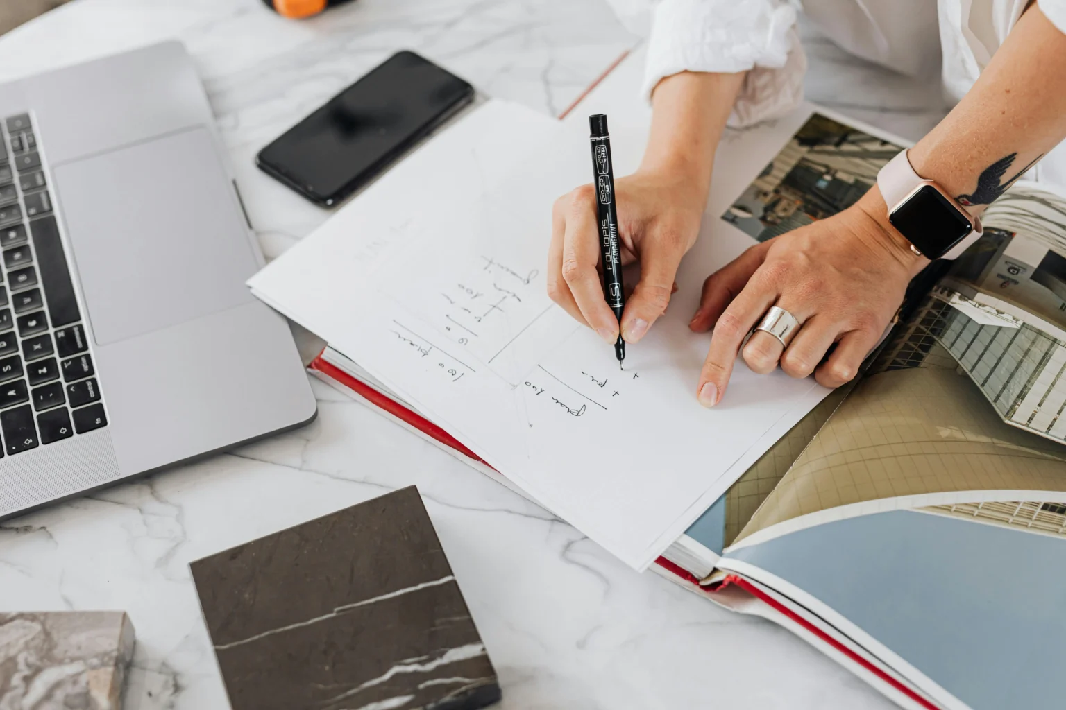 person writing in a notebook while planning a tile project