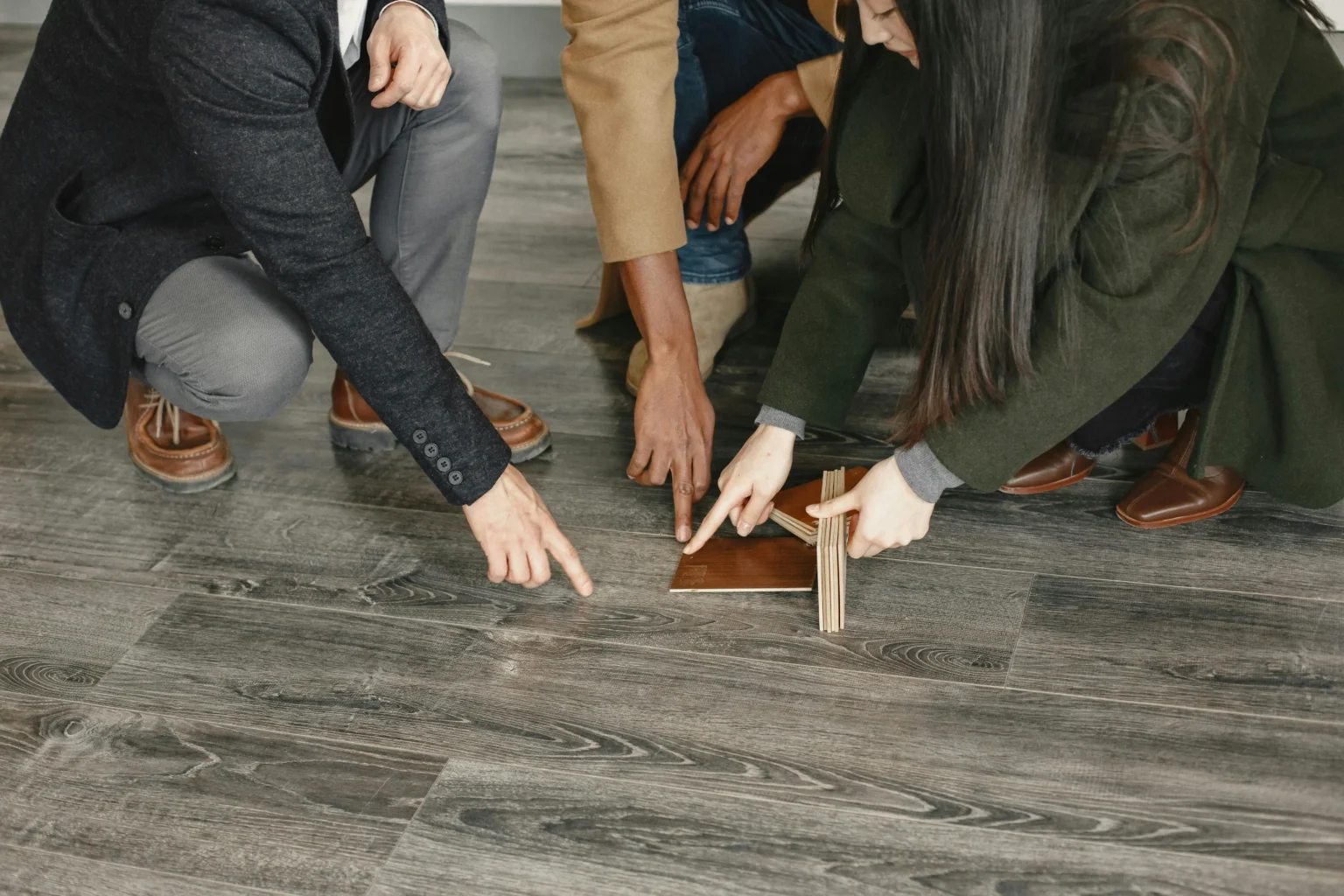 People comparing flooring samples to choose a material